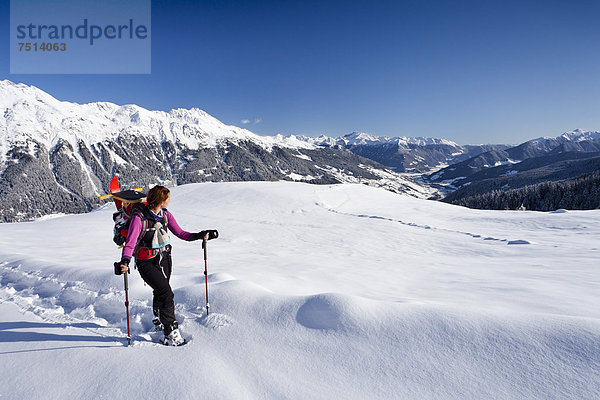 Schneeschuhwanderin beim Aufstieg zur Jagelealm  hinten das Ridnauntal  der Rosskopf und die Telfer Weißen  Südtirol  Italien  Europa