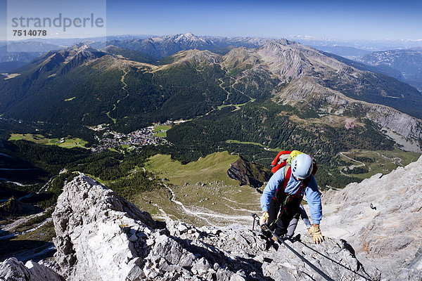 Bergsteiger beim Aufstieg über die Via ferrata Bolver-Lugli auf die Cima Vezzana in der Palagruppe  unten das Dorf San Martino di Castrozza  Trentino  Italien  Europa