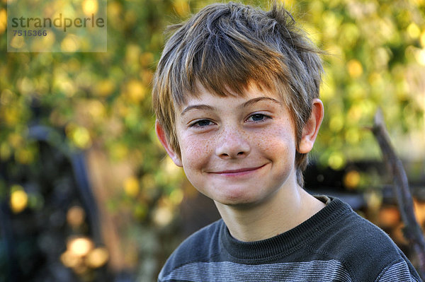 Sommersprossiger Junge  zehn Jahre  grinst  Portrait  Othenstorf  Mecklenburg-Vorpommern  Deutschland  Europa