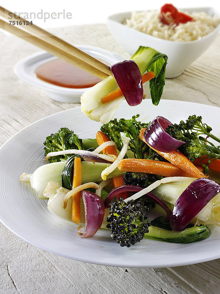 Orientalisches Wok-Gemüse  mit Ess-Stäbchen  mit Reis und einem Chili-Dip