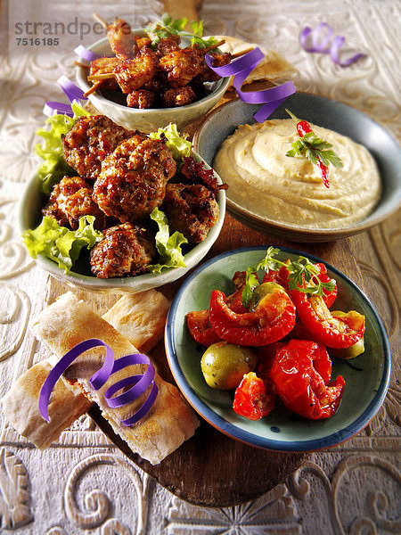 Party-Buffet  Speisen mit Hummus  Fleischbällchen  Satay-Hühnchen und sonnengetrockneten Tomaten