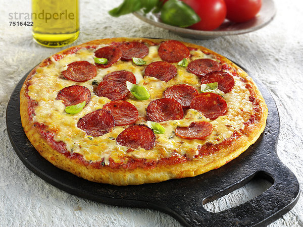 Pizza mit Pfeffersalami  Käse  Chili und Basilikum