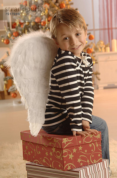 Geschenk sitzend Junge - Person frontal Weihnachtsbaum Tannenbaum Kleidung Engel