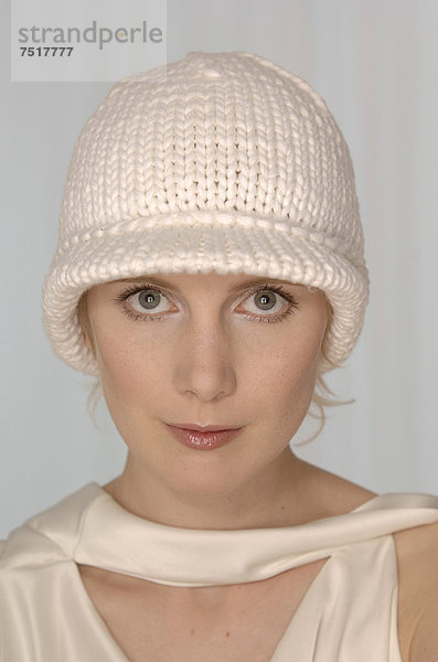 Blonde Frau mit weißer Wollmütze  Portrait