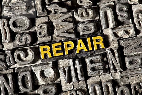 'Alte Bleilettern bilden das englische Wort ''REPAIR'''