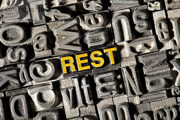 'Alte Bleilettern bilden das Wort ''REST'''