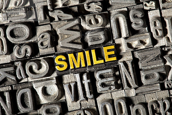 'Alte Bleilettern bilden das englische Wort ''SMILE'''