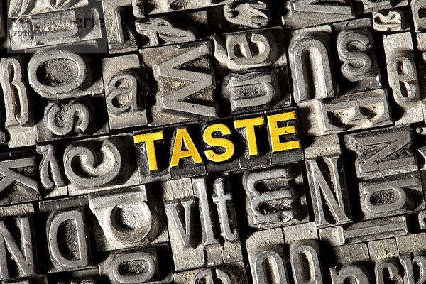 'Alte Bleilettern bilden das englische Wort ''TASTE'''