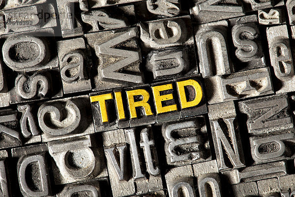 'Alte Bleilettern bilden das englische Wort ''TIRED'''