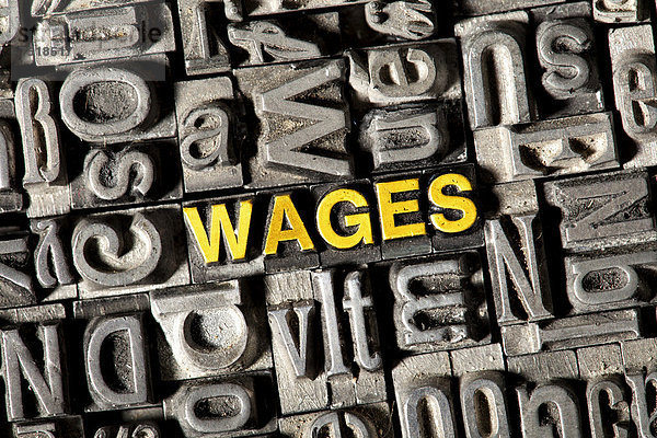 'Alte Bleilettern bilden das englische Wort ''WAGES'''