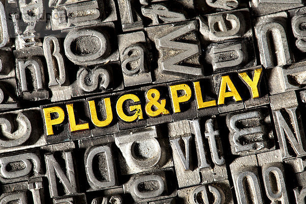 'Alte Bleilettern bilden den englischen Begriff ''PLUG and PLAY'''