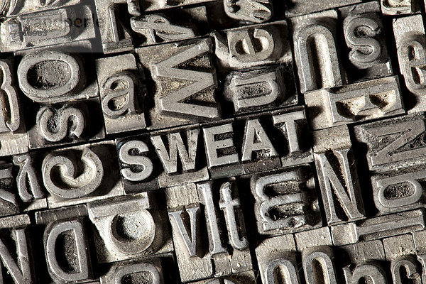 'Alte Bleilettern bilden das englische Wort ''SWEAT'''