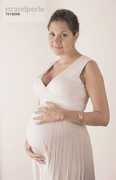 Schwangere Frau mit den Händen auf ihrem Bauch