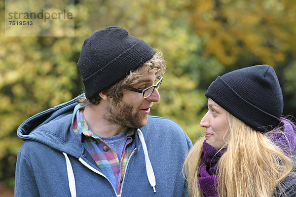Ein junges Paar unterhält sich im herbstlichen Park  Baden-Württemberg  Deutschland  Europa  ÖffentlicherGrund