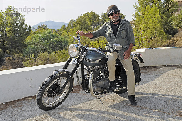 Älterer Mann sitzt auf einer Triumph Tiger 500 cc  Baujahr 1956  englisches Motorrad  Altea  Costa Blanca  Spanien  Europa  ÖffentlicherGrund