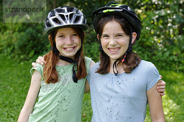 Mädchen mit Fahradhelmen  Schlamm verspritzt  nach einer Mountainbiketour  Radtour