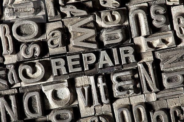 'Alte Bleilettern bilden das englische Wort ''REPAIR'''