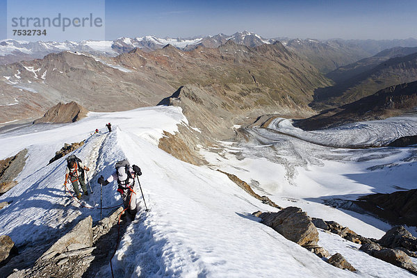 Wanderer auf dem Gipfelgrat beim Aufstieg zum Similaun auf dem Niederjochferner im Schnalstal  hinten der Marzell-Kamm  Südtirol  Italien  Europa