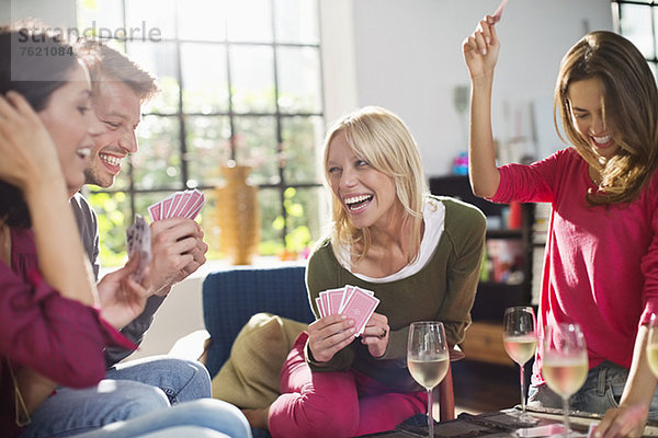 Freunde spielen Kartenspiel im Wohnzimmer