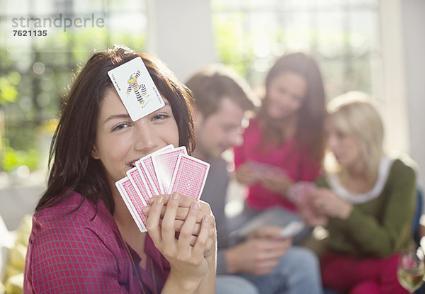 Lächelnde Frau beim Kartenspiel