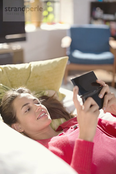 Frau spielt Videospiele auf dem Sofa