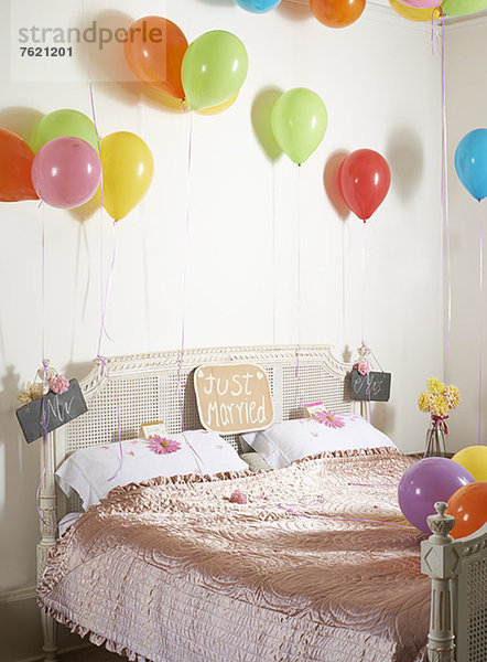 Bunte Luftballons über dem Ehebett