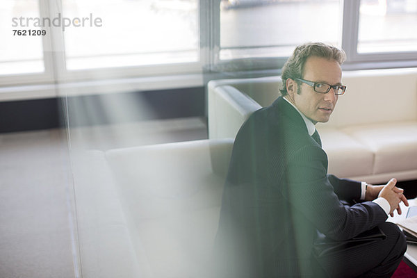 Geschäftsmann sitzend in der Büro-Lobby