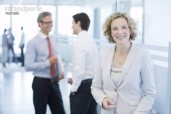 Geschäftsfrau lächelt im Büroflur