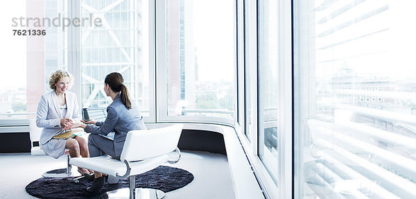 Geschäftsfrauen im Gespräch in der Bürolobby