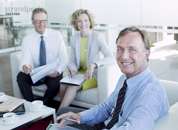 Geschäftsleute lächeln in der Bürolobby