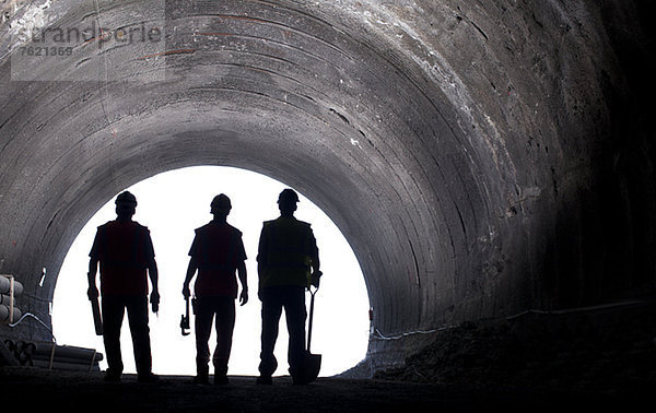 Silhouette der Arbeiter im Tunnel