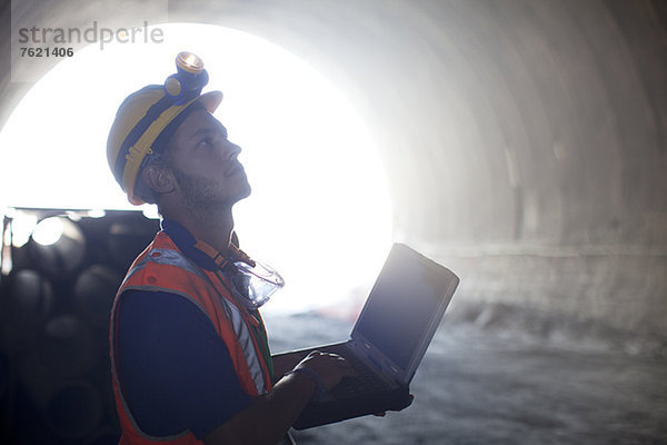 Arbeiter mit Laptop im Tunnel