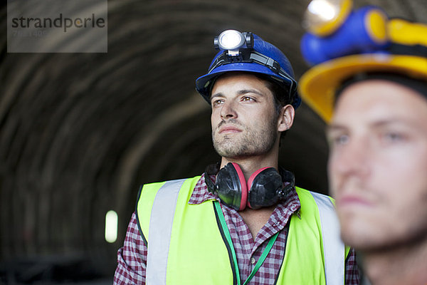 Arbeiter schauen aus dem Tunnel heraus