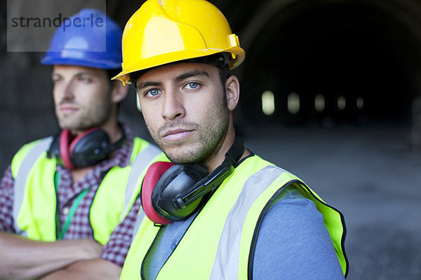 Arbeiter schauen aus dem Tunnel heraus