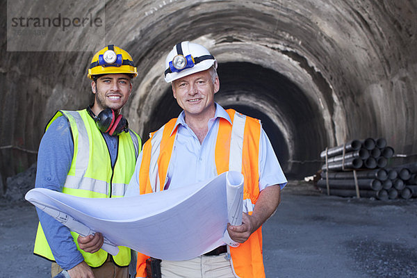 Arbeiter lesen Blaupausen im Tunnel