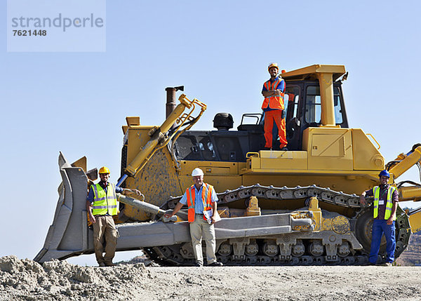 Arbeiter auf Bulldozer lächeln im Steinbruch