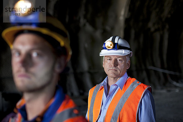 Geschäftsmann und Arbeiter im Tunnel stehend