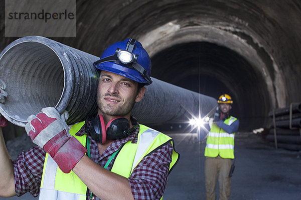 Arbeiter mit langem Rohr im Tunnel