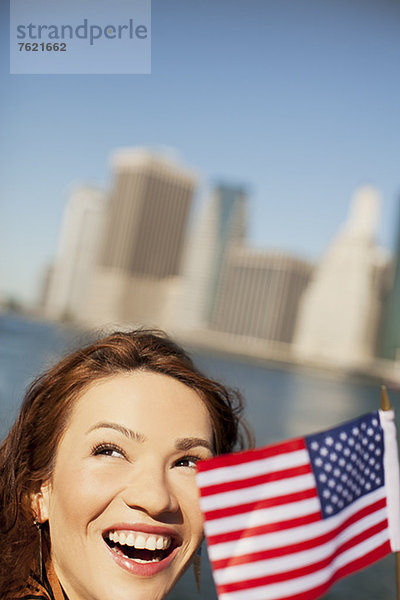 Frau mit amerikanischer Flagge im Stadtbild