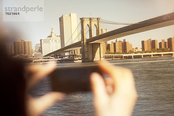 Hände fotografieren Stadtbrücke und Stadtbild