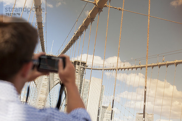 Mann fotografiert Stadtbrücke