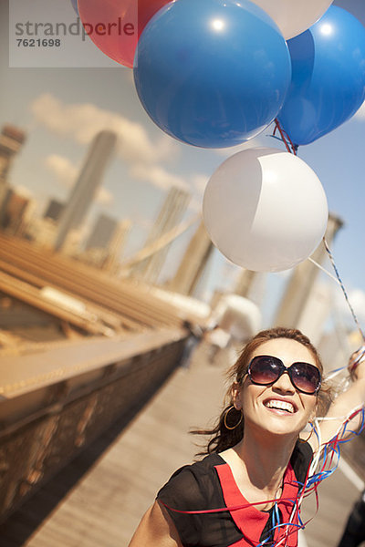 Frau mit Luftballons auf der Stadtbrücke