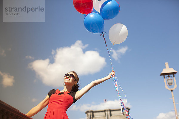 Frau mit Luftballons auf der Stadtbrücke