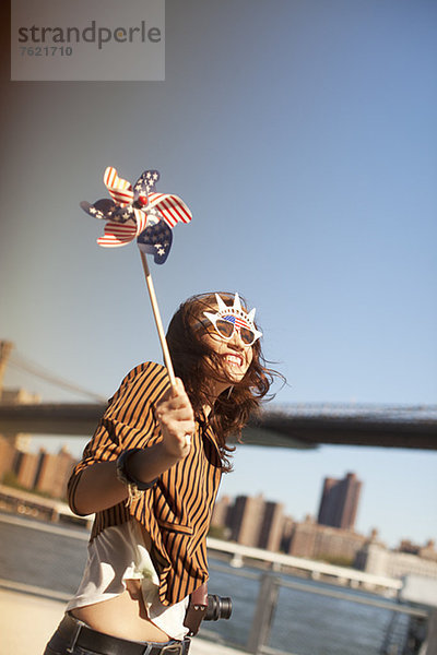 Frau mit neuartiger Sonnenbrille und Windrad von city bridge