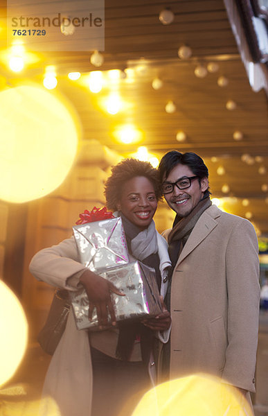 Paar mit verpackten Geschenken auf der Stadtstraße