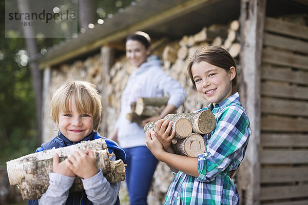 Kinder mit Brennholz im Freien