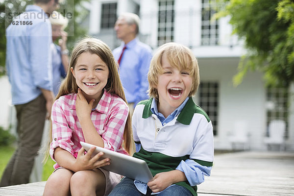 Kinder  die das digitale Tablett gemeinsam im Freien benutzen