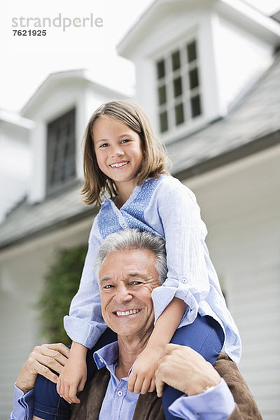 Mann mit Enkelin auf der Schulter im Freien