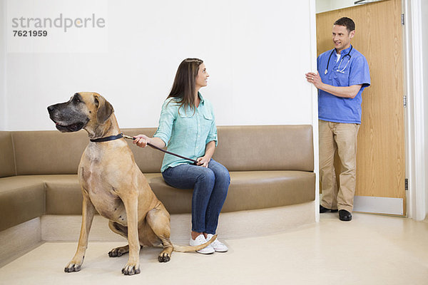 Tierarzt ruft Besitzer und Hund in die Tierarztpraxis