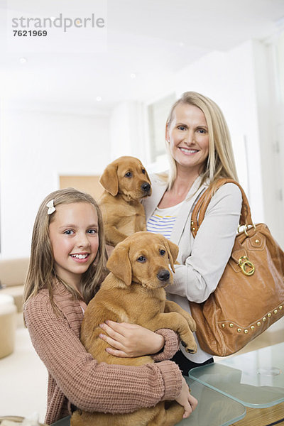 Mutter und Tochter mit Hunden in der Tierarztpraxis